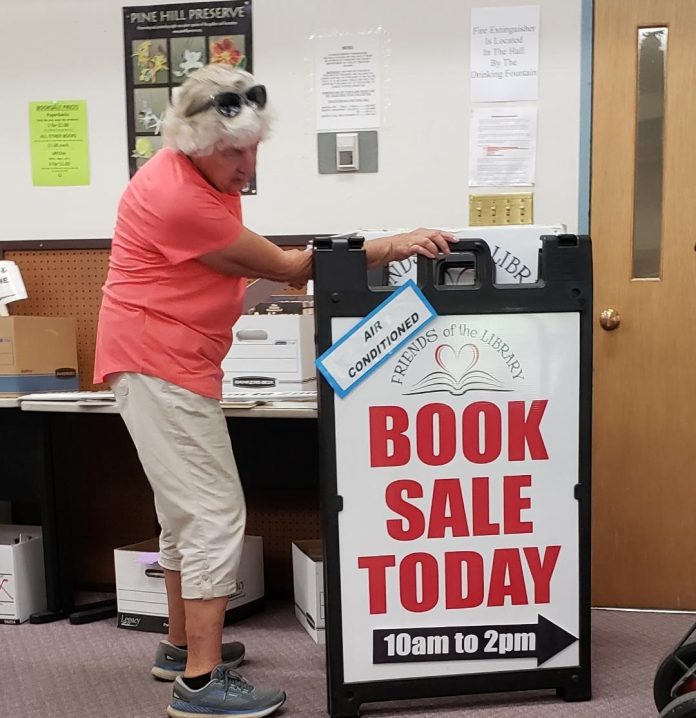 Friends group president Bev McColm sets up signboards to help promote the book sale. Photos courtesy Quincy Friends of the Plumas County Library