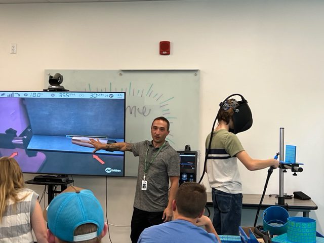 Jesse Lazzarino, the new coordinator of the manufacturing and metal fabrication pathway at Plumas Charter School, instructs students on the AugmentedArc virtual reality learning technology. Photo by Taletha Washburn