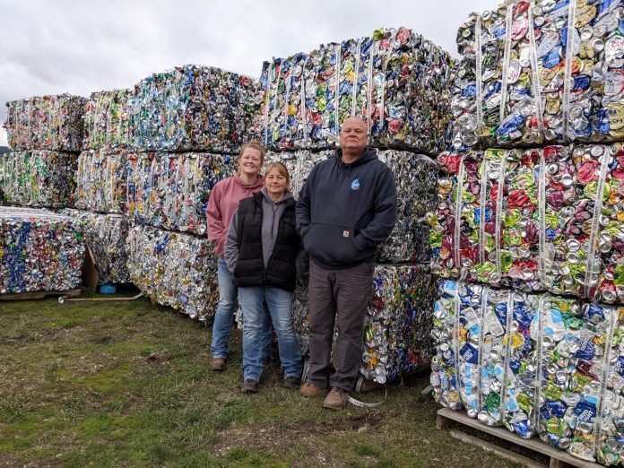 The Neiman family — Lisa, center, Curt and Brittney — pose with baled cans at Quincy Recycler, their new buy-back recycling center. Photo by Ingrid Burke